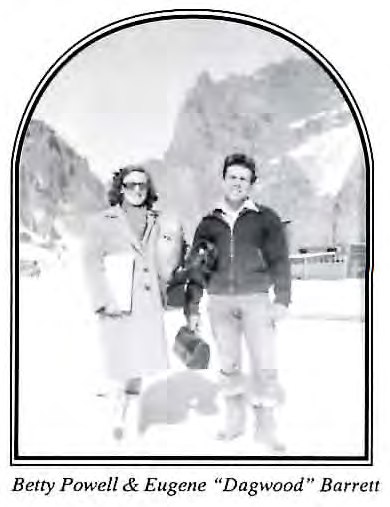 Black-and-white photograph of a woman and a man standing together outdoors in a snowy mountain setting.
