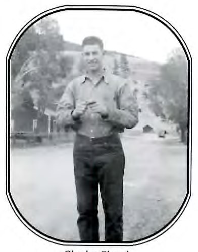 Black-and-white photograph of a young man standing on a street, buttoning his shirt cuffs.
