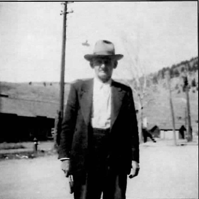 Photo of Mayor Royal I. Fisher standing outdoors in a suit and hat.